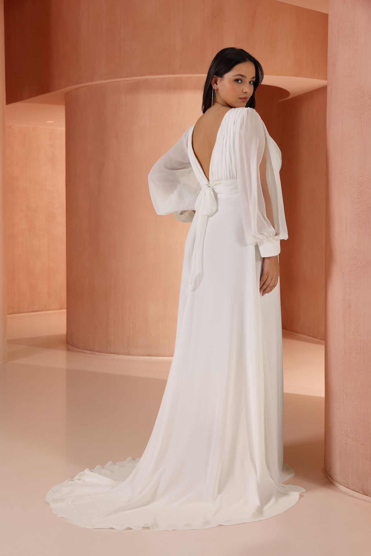 Elegantes Chiffon-Hochzeitskleid mit tiefem V-Ausschnitt, langen transparenten Ärmeln und hohem Beinschlitz – modernes, fliessendes Brautkleid für einen leichten Wedding-Dress-Look.