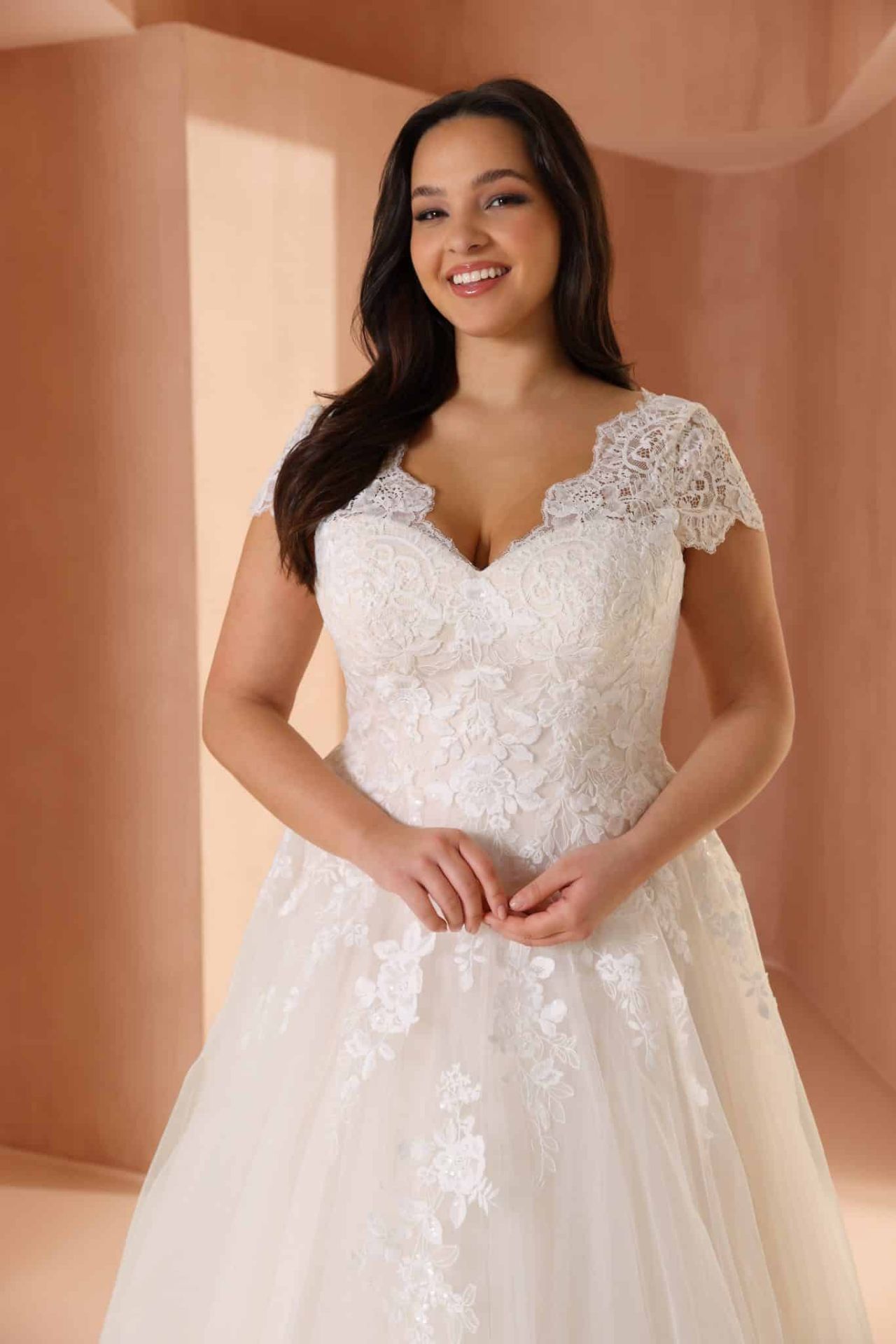 Curvy Prinzessin-Brautkleid mit V-Ausschnitt, Spitzenoberteil, zarten Trägern, floralen Applikationen und voluminösem Tüllrock – Weddingdress bei Brautfashion in Sins