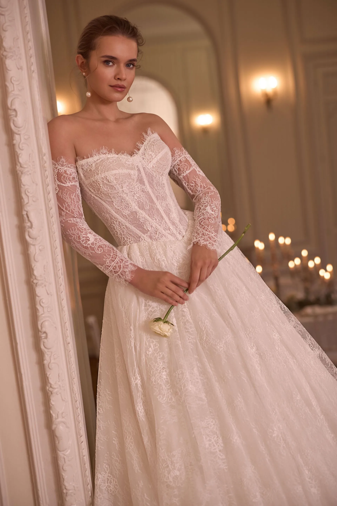 Romantisches Brautkleid mit Off-Shoulder-Ausschnitt, langen Spitzenärmeln, transparenter Corsage und floralem Spitzenrock – Weddingdress bei Brautfashion in Sins