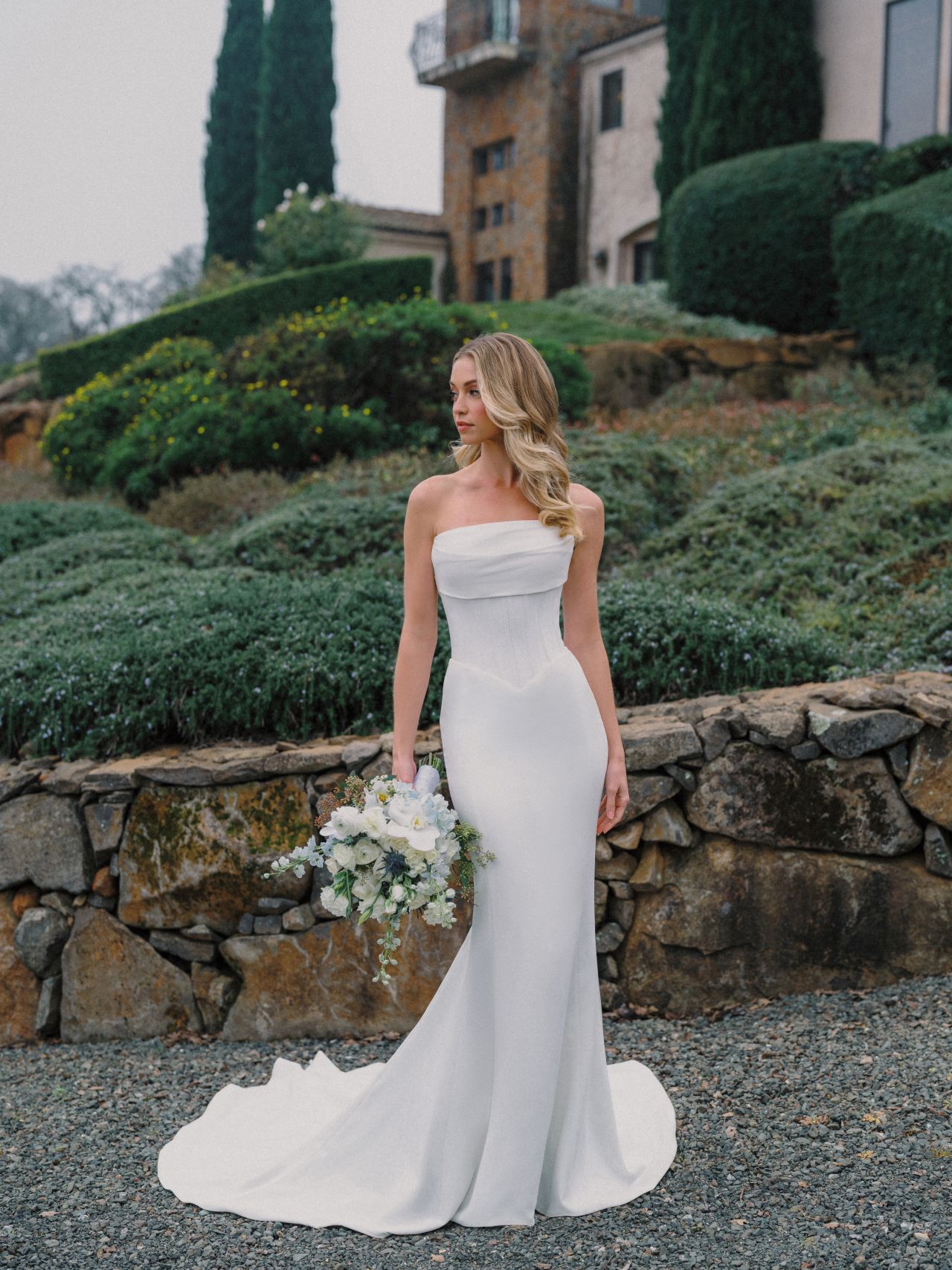 Clean-Chic-Fit-and-Flare-Brautkleid mit trägerloser Drapierung, figurbetonter Silhouette und schlichter Schleppe – Weddingdress bei Brautfashion in Sins
