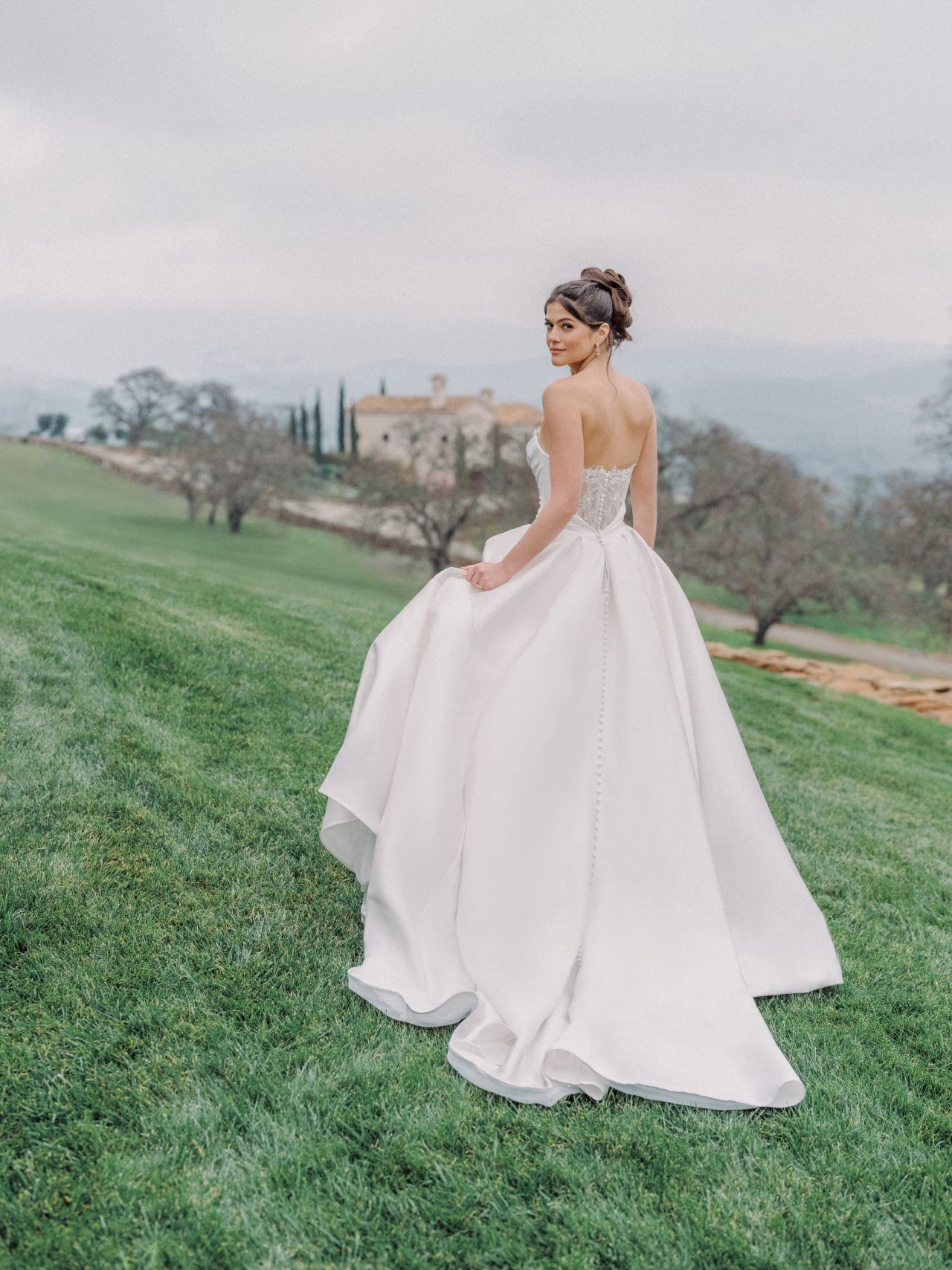 Clean-Chic-Brautkleid mit trägerloser Drapierung, feiner Spitze, Basque Taille und romantischem Brautstrauss – Weddingdress bei Brautfashion in Sins