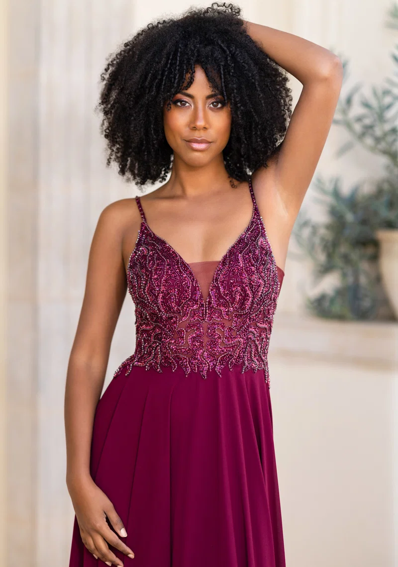 Bordeauxfarbenes Festkleid mit Spaghettiträgern, V-Ausschnitt, transparentem Spitzenoberteil, Perlen- und Glitzerdetails sowie fliessendem Rock – Festmode bei Brautfashion in Sins