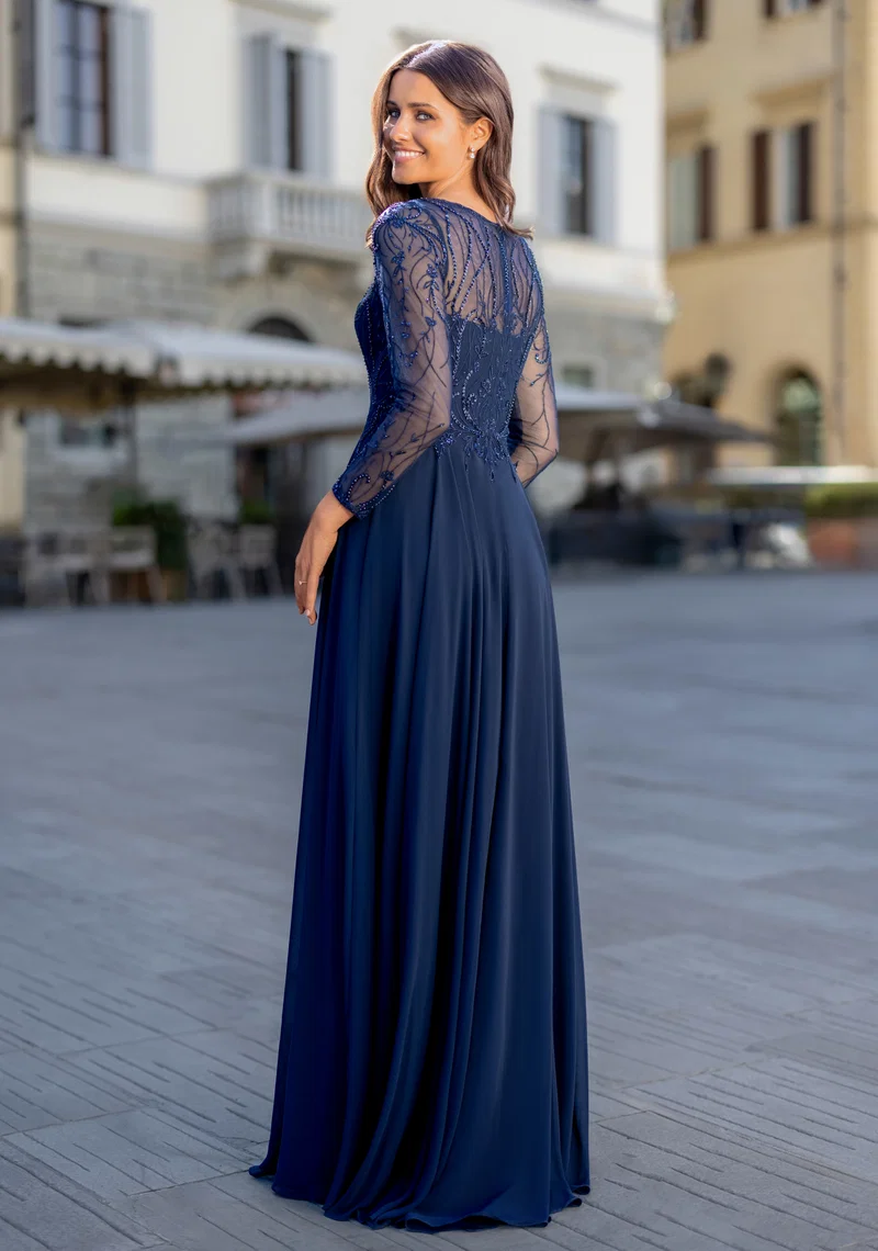 Elegantes dunkelblaues Festkleid mit langen transparenten Spitzenärmeln, Perlen- und Glitzerdetails, Rundhalsausschnitt und fliessendem Rock – Festmode bei Brautfashion in Sins