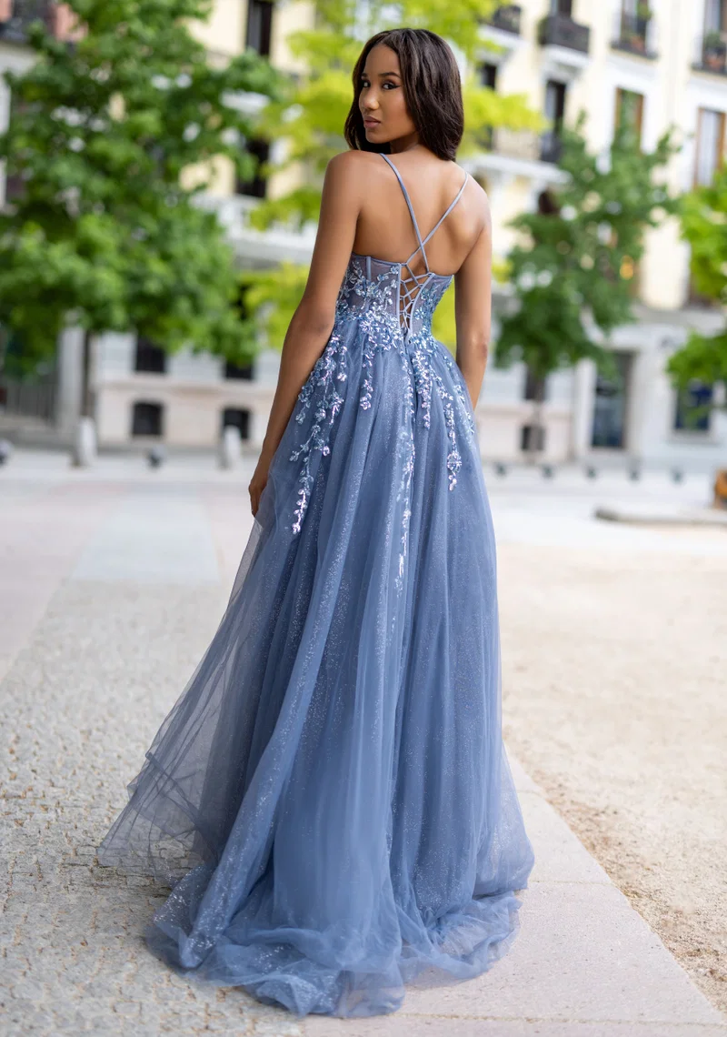 Blau-graues Festkleid mit Spaghettiträgern, transparenter Corsage, floralen Applikationen, Perlen- und Glitzerdetails, Beinschlitz und fliessendem Tüllrock – Festmode bei Brautfashion in Sins