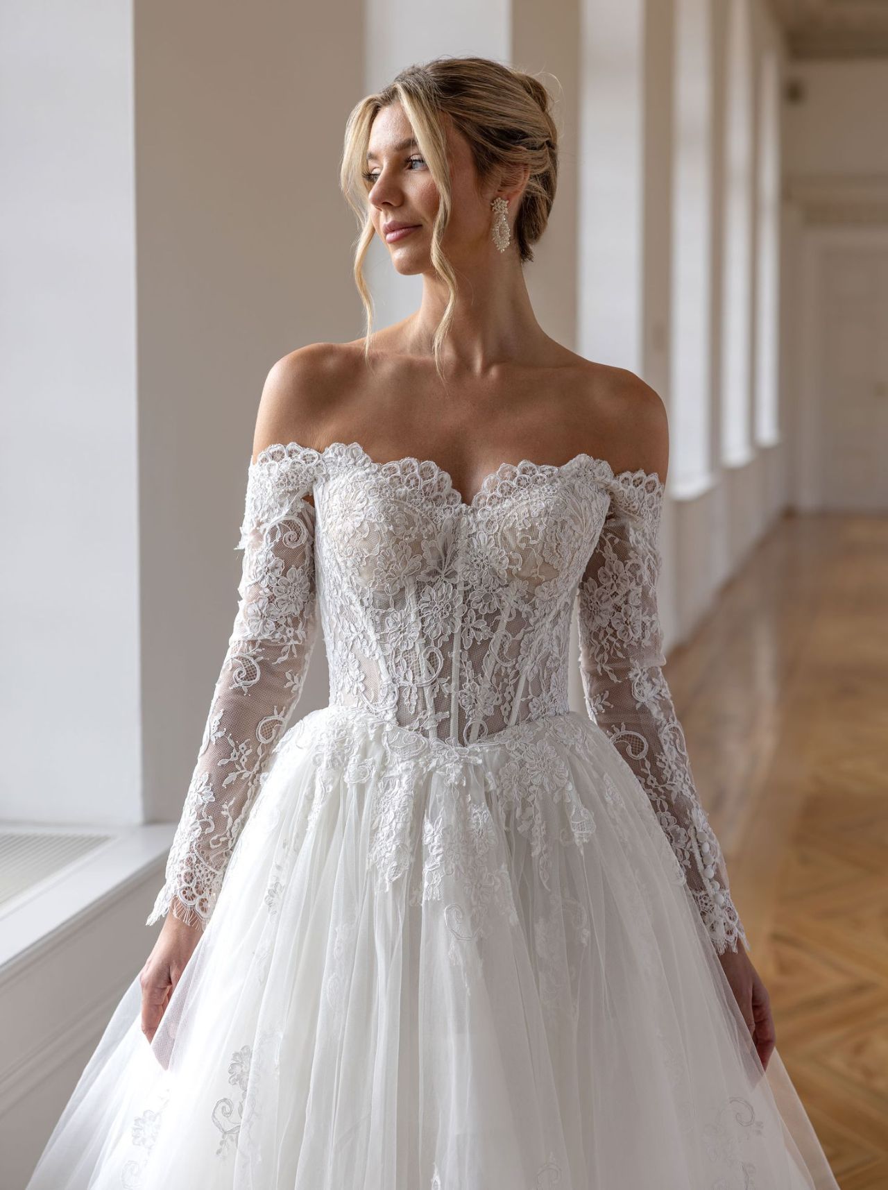 Romantisches Hochzeitskleid mit Off-Shoulder-Spitzenärmeln, transparenter Corsage, Herzausschnitt, Schnürrücken, fliessendem Tüllrock und langer Schleppe – Vorder- und Rückenansicht bei Brautfashion in Sins