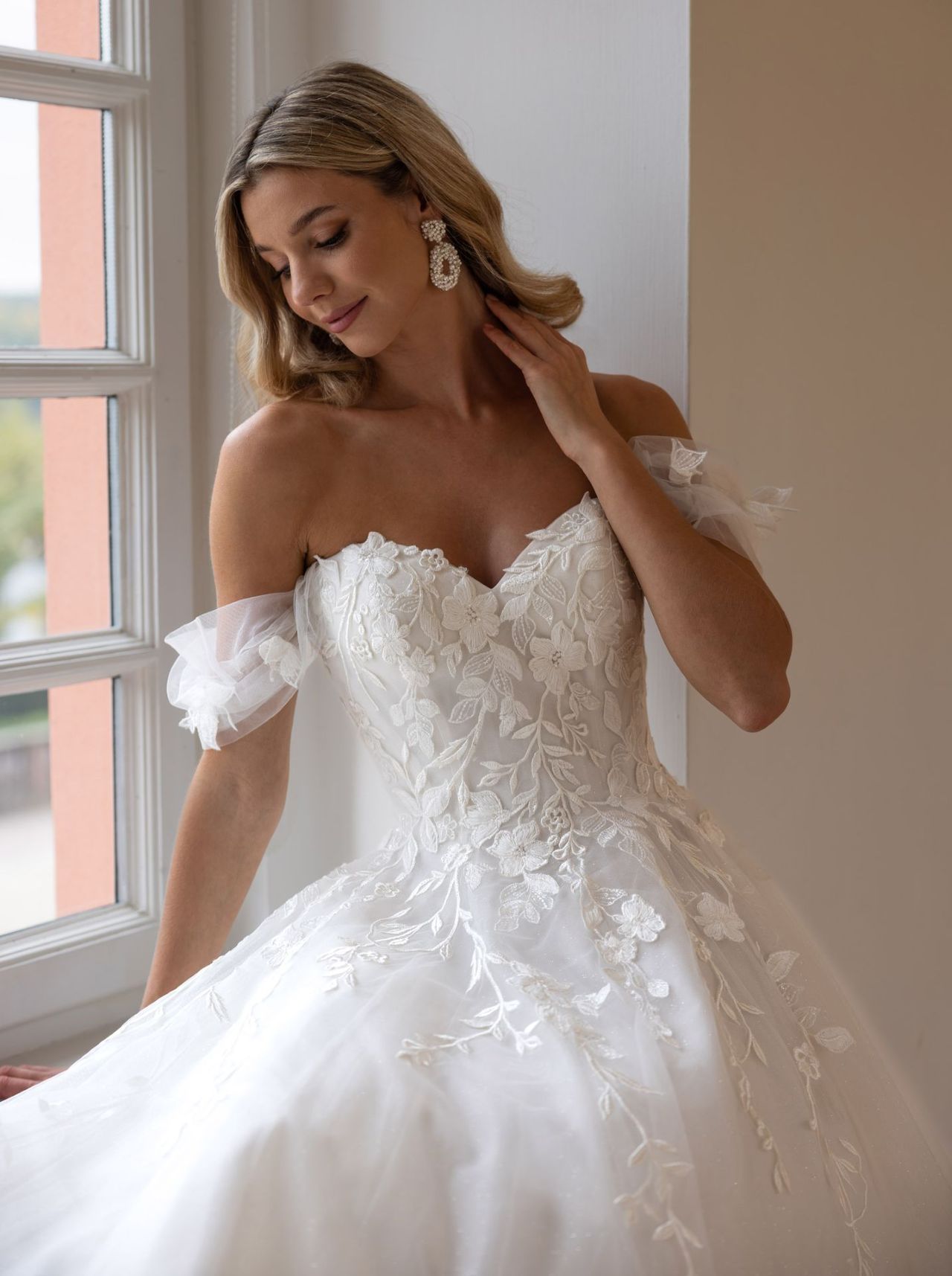 Romantisches Curvy-Hochzeitskleid mit Off-Shoulder-Ärmeln, floraler Spitzen-Corsage, herzförmigem Ausschnitt, Tüllrock, Schnürung und fliessender A-Linien-Silhouette – Brautmode bei Brautfashion in Sins