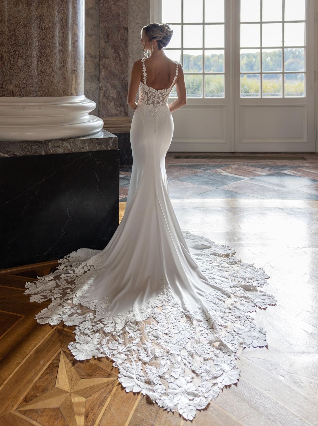 Elegantes Fit-and-Flare-Hochzeitskleid mit Spaghettiträgern, transparenter Spitzen-Corsage, tiefem V-Ausschnitt, figurbetonter Silhouette, Illusion-Rücken und langer floraler Spitzenschleppe – Vorder- und Rückenansicht bei Brautfashion in Sins
