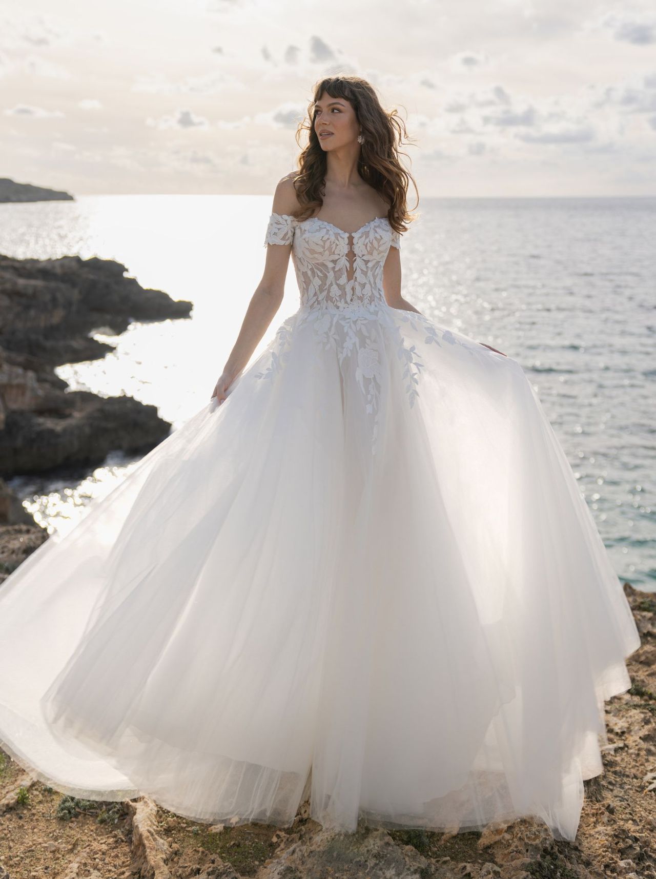 Romantisches Hochzeitskleid mit Off-Shoulder-Spitzenärmeln, transparenter Corsage, herzförmigem Ausschnitt, voluminösem Tüllrock, Illusion-Rücken und langer Schleppe – Vorder- und Rückenansicht bei Brautfashion in Sins