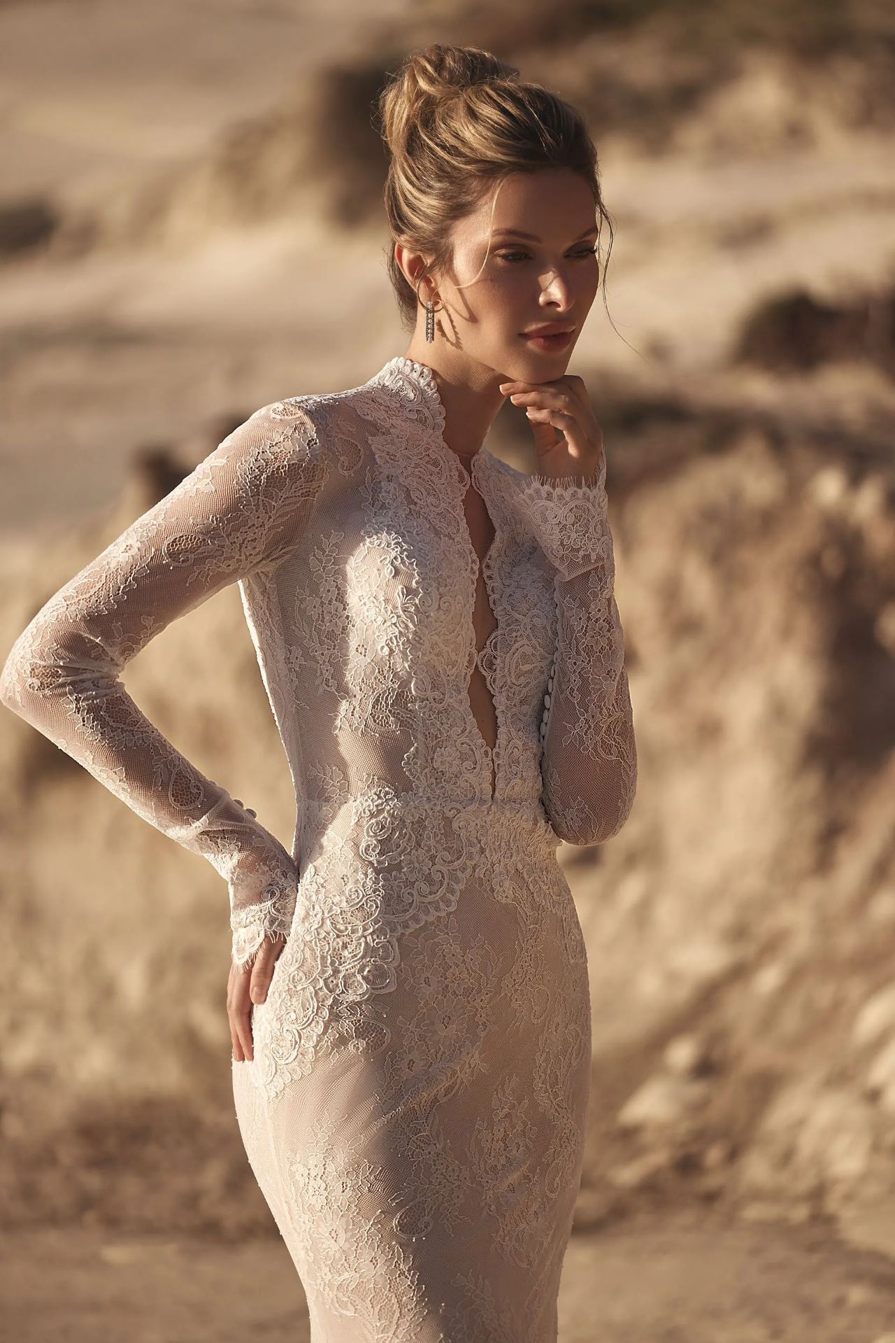 Elegantes Fit-and-Flare-Hochzeitskleid mit langen Spitzenärmeln, hochgeschlossenem Kragen, tiefem V-Ausschnitt, All-over Lace, offenem Rücken, Knopfleiste und körperbetonter Silhouette – Vorder- und Rückenansicht bei Brautfashion in Sins