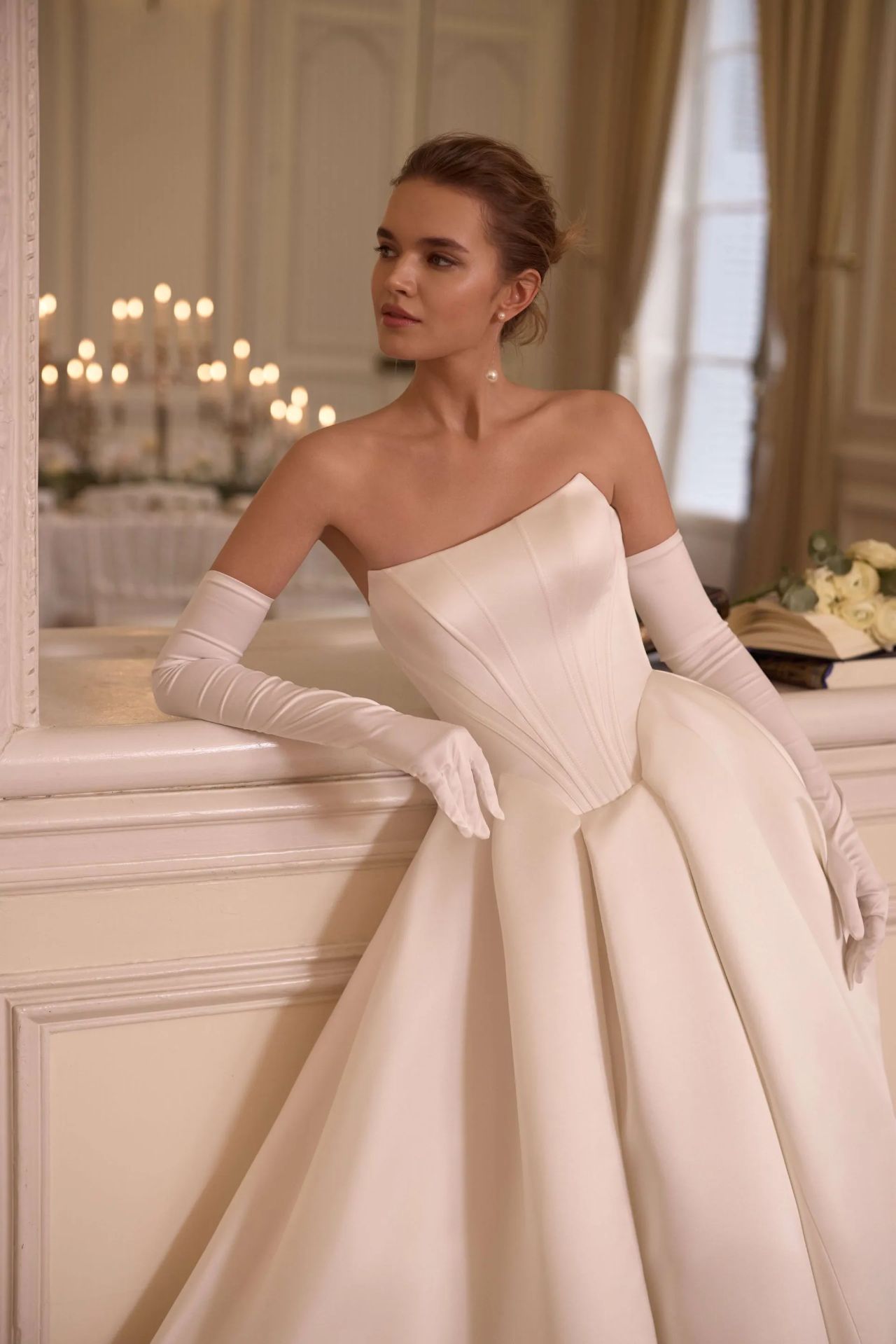 Cleanes Hochzeitskleid mit trägerloser Corsage, asymmetrischem Ausschnitt, Basque-Taille, langen Handschuhen, voluminösem Satinrock, tiefem Rücken, Knopfleiste und langer Schleppe – Vorder- und Rückenansicht bei Brautfashion in Sins